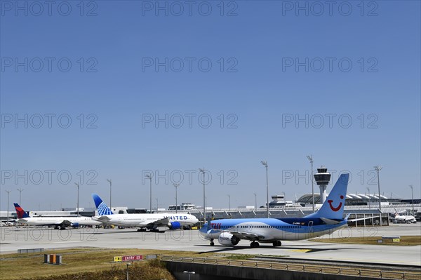 TUI Boeing B737-800 MAX taxiing on apron in front of Terminal 1 with tower, Munich Airport, Upper Bavaria, Bavaria, Germany, Europe