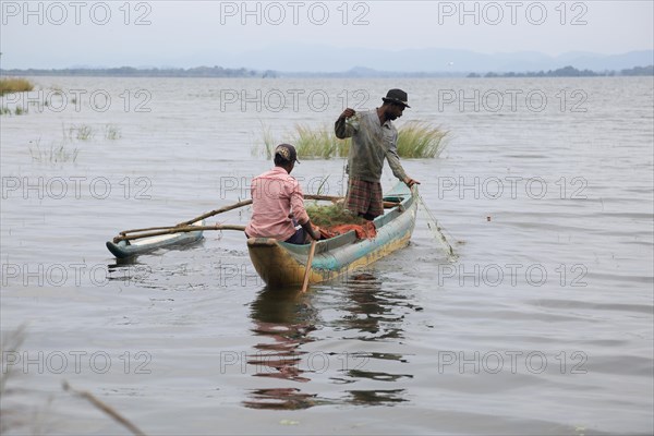 Men fishing from a canoe, Polonnaruwa, Central Province, Sri Lanka, Asia