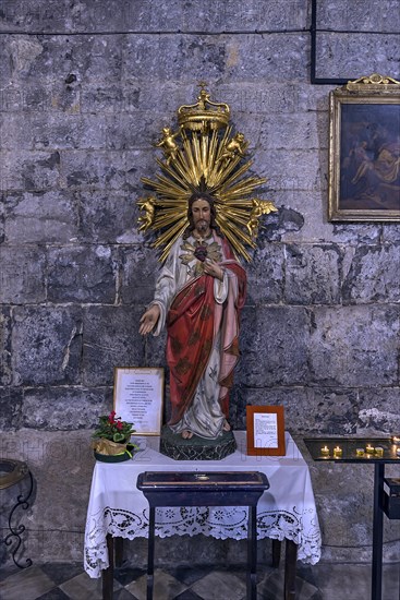 Chistus figure with sacrificial candles in the church of San Donato, 12th century, Via S. Donato, 10, in the centre of Genoa, Italy, Europe
