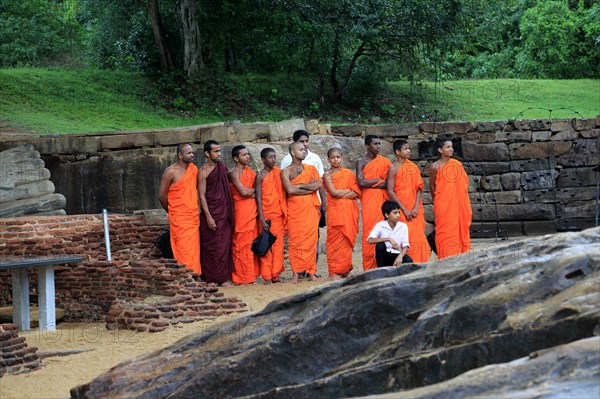 Orange robed monks, Gal Viharaya, UNESCO World Heritage Site, the ancient city of Polonnaruwa, Sri Lanka, Asia
