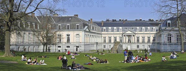 Tourists sunbathing in park at the Egmont Palace, Egmontpaleis, Palais d'Egmont in Brussels, Belgium, Europe