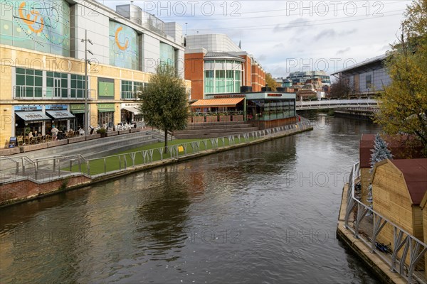 River Kennet flowing past The Oracle shopping centre in town centre, Reading, Berkshire, England, UK