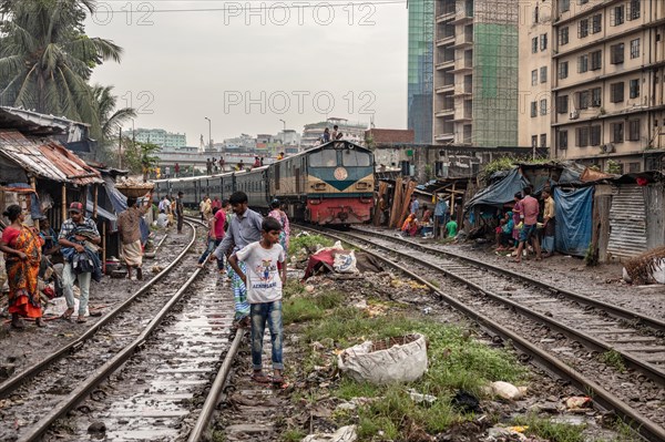 A train passes through an informal settlement built close to a railway line, Tejgaon Slum, Area, Dhaka, Bangladesh, Asia