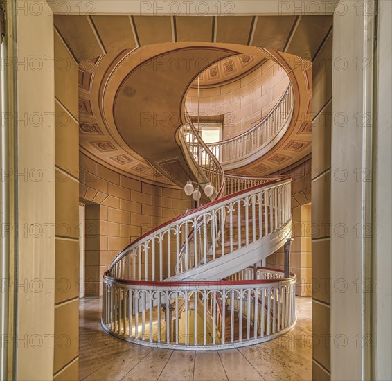 A spiral staircase in a building with a historic interior and warm lighting tones, Schachtrupp Villa, Lost Place, Osterode am Harz, Lower Saxony, Germany, Europe