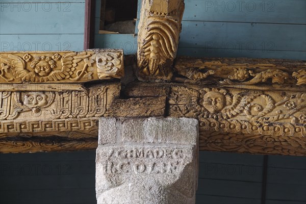 Carved wooden beam on stone pillar, Enclos Paroissial parish enclosure of Guimiliau, Finistere Penn ar Bed department, Brittany Breizh region, France, Europe