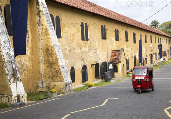 Motorised rickshaw by fort walls inside the historic town of Galle, Sri Lanka, Asia