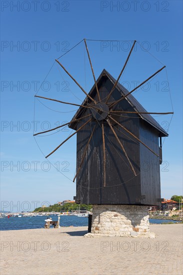 Close-up of a historic windmill on the dam in front of a bright blue sky by the sea, landmark, Black Sea, Nesebar, Nessebar, Burgas, Bulgaria, Europe