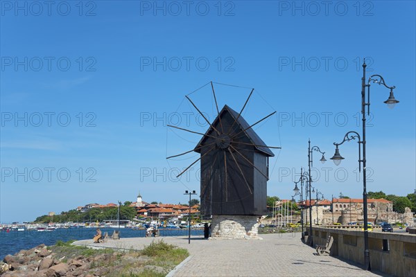 Traditional windmill on the embankment on a sunny day on the coastal promenade with blue sky, landmark, Black Sea, Nesebar, Nessebar, Burgas, Bulgaria, Europe