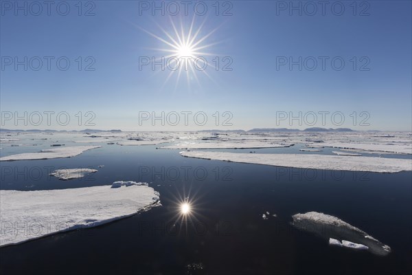 Midnight sun over the Arctic Ocean with drifting ice floes, north of the Arctic Circle at Nordaustlandet, Svalbard, Spitsbergen, Norway, Europe