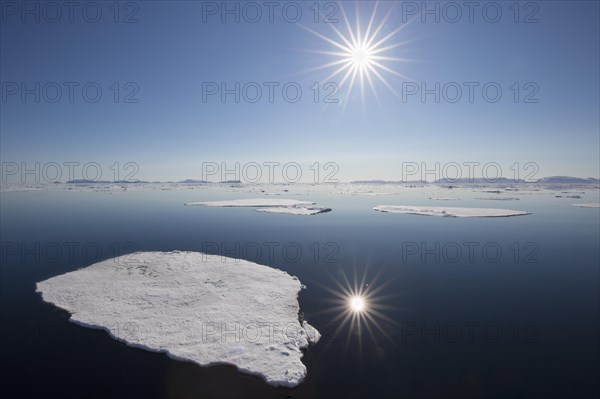 Midnight sun over the Arctic Ocean with drifting ice floes, north of the Arctic Circle at Nordaustlandet, Svalbard, Spitsbergen, Norway, Europe