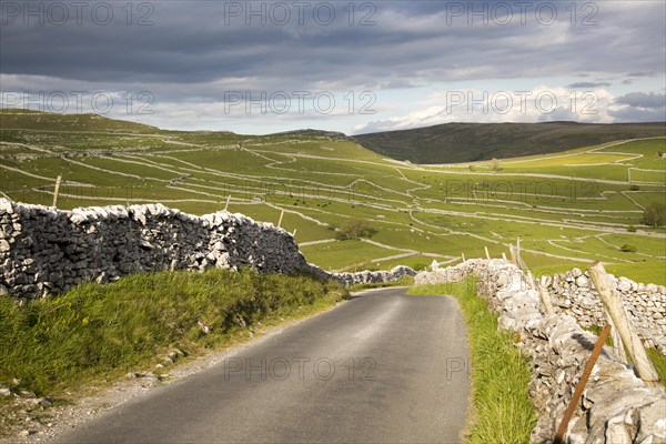 Country lane and dry stonewalls, Malham, Yorkshire Dales national park, England, UK