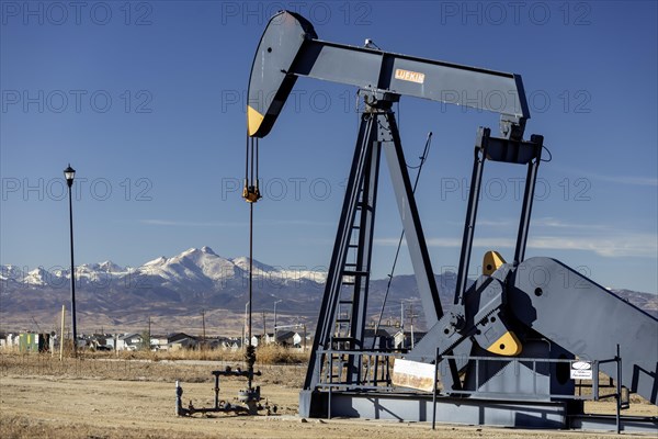 Frederick, Colorado, An oil well near a housing subdivision on Colorado's front range, with Mount Meeker and Longs Peak in Rocky Mountain National Park in the distance