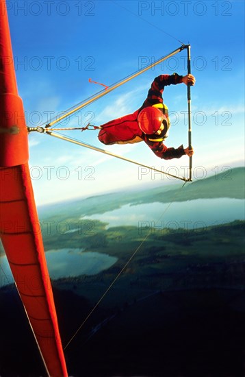 Hang glider pilot with red hangglider and red helmet in a steep curve, also called knife flight, hanggliding, started from Tegelberg, near Fuessen, Allgaeu, Bavaria, Germany, Europe