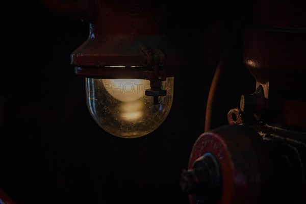 An atmospheric light from an antique lamp in a dark part of a locomotive, Dahlhausen railway depot, Lost Place, Dahlhausen, Bochum, North Rhine-Westphalia, Germany, Europe