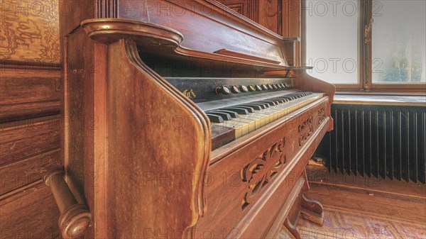 An old piano with open keyboard, surrounded by rich wood carving, Villa Woodstock, Lost Place, Wuppertal, North Rhine-Westphalia, Germany, Europe