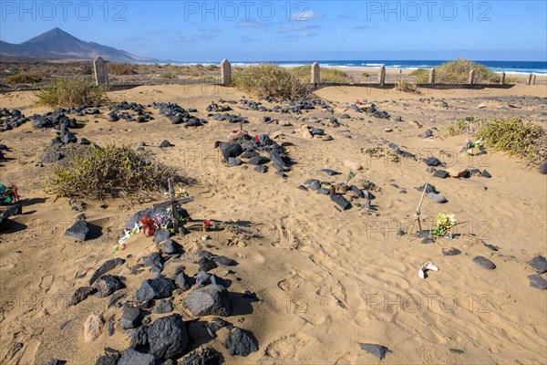 View of old sandy historical cemetery from 1950s with several graves marked by stones from abandoned village of Cofete on west coast of Jandia peninsula, in the background Atlantic Ocean, Cofete, Jandia, Fuerteventura, Canary Islands, Canary Islands, Spain, Europe