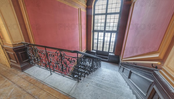 Entrance area with curved staircase, red walls and wooden elements, Villa Woodstock, Lost Place, Wuppertal, North Rhine-Westphalia, Germany, Europe