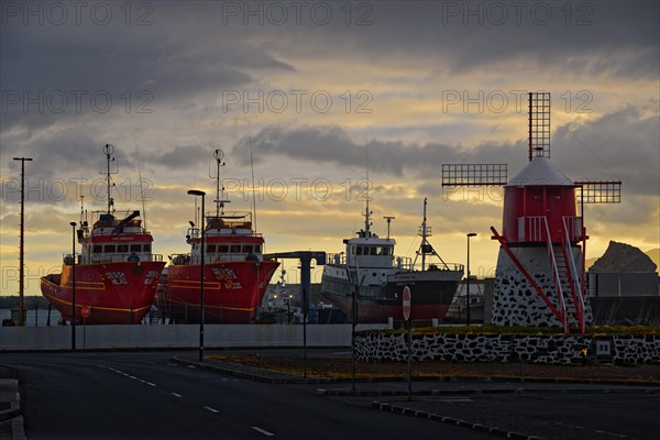 Fishing boats in the harbour of Madalena at sunrise, next to a red windmill, Madalena, Pico, Azores, Portugal, Europe