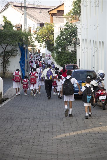 School girls in uniform walking in a street in the historic town of Galle, Sri Lanka, Asia