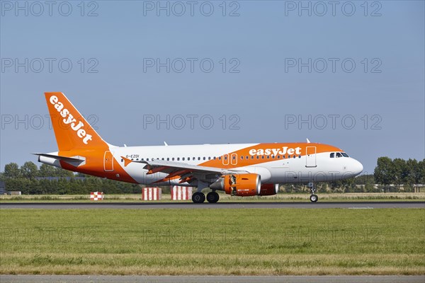 EasyJet Airbus A319-111 with registration G-EZDI lands on the Polderbaan, Amsterdam Schiphol Airport in Vijfhuizen, municipality of Haarlemmermeer, Noord-Holland, Netherlands