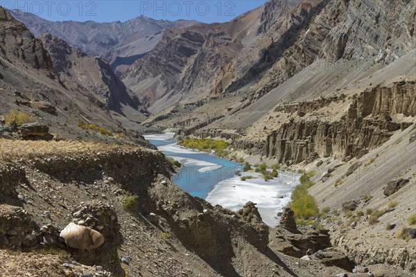 Tsarab River, cutting across the Zanskar Range of the Himalayas in Ladakh, with barren mountains above it, seen on a clear, blue-sky day, late in the summer, when glacier rivers like this one slow down, carry less sediment and become turquoise blue. Kargil District, Union Territory of Ladakh, India, Asia