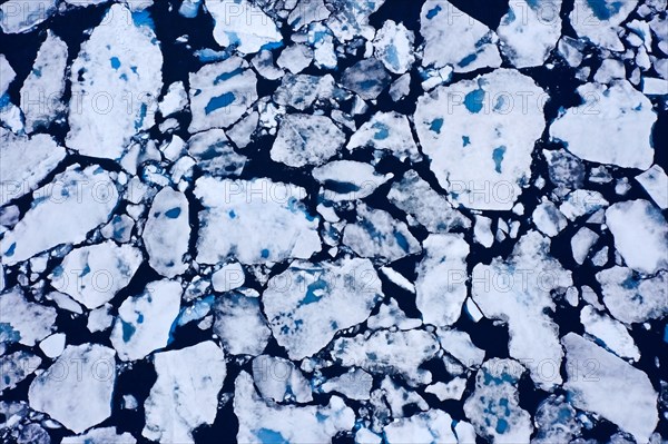 Aerial view over sea ice, drift ice, ice floes with melt ponds containing freshwater in the Arctic Ocean, Nordaustlandet, Svalbard, Spitsbergen