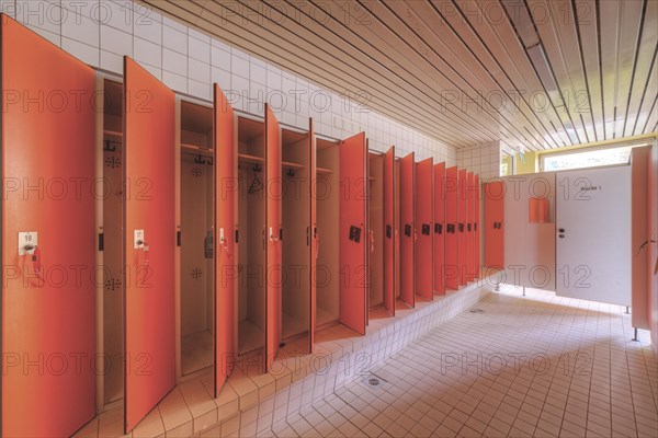A set of red changing cubicles in a clean, empty room, Bad am Park, Lost Place, Essen, North Rhine-Westphalia, Germany, Europe