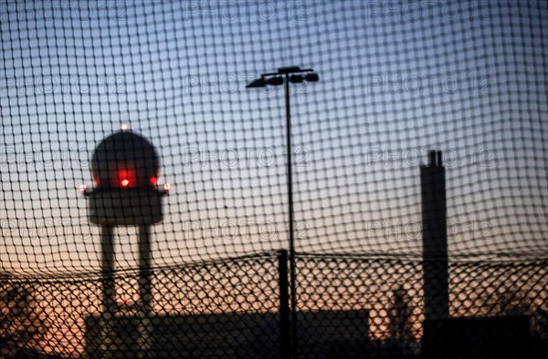 Evening mood at Tempelhofer Feld, view through a fence to the radar tower at the former Tempelhof Airport, Berlin, 15 December 2022