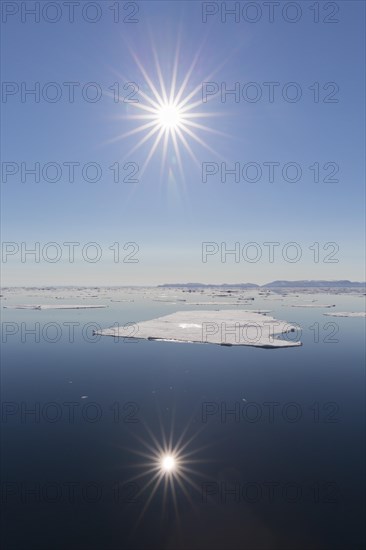 Midnight sun over the Arctic Ocean with drifting ice floes, north of the Arctic Circle at Nordaustlandet, Svalbard, Spitsbergen, Norway, Europe