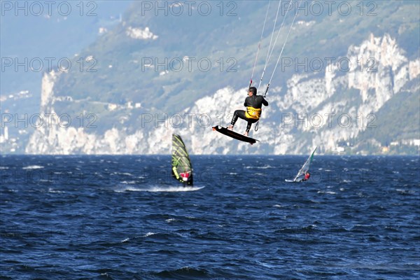 Windsurfers surfing in strong winds on Lake Garda near Malcesine, Veneto, Italy, Europe