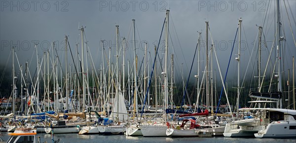 Sailboats in the sunny harbour of Horta with dark clouds above, Horta, Faial Island, Azores, Portugal, Europe