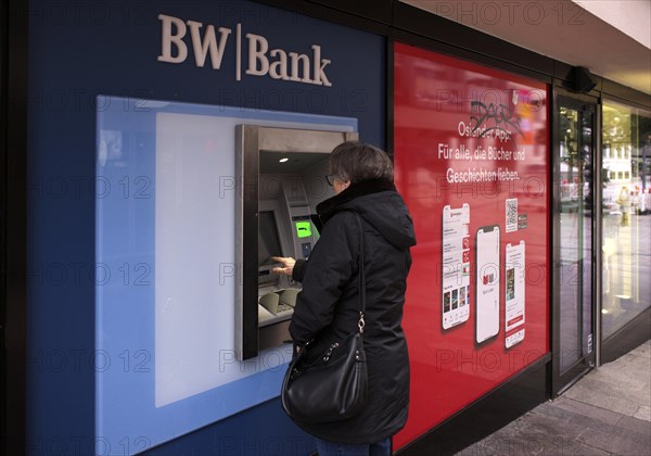 Elderly woman, best ager, types in PIN, ATM of BW-Bank Baden-Wuerttembergische Bank, logo, Stuttgart, Baden-Wuerttemberg, Germany, Europe