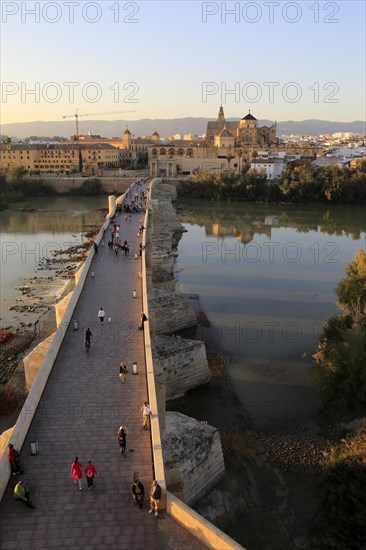 Roman bridge spanning river Rio Guadalquivir with Mezquita cathedral buildings, Cordoba, Spain, Europe