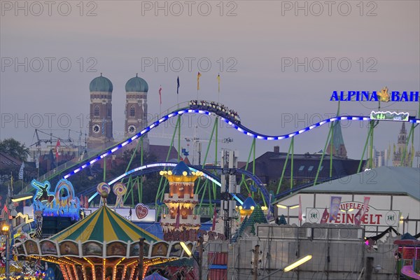View over the Oktoberfest, in the evening with alpine railway in front of the Church of Our Lady, Munich, Bavaria, Germany, Europe