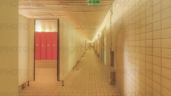 A corridor with tiled walls and doors on both sides leading to changing room lockers, Bad am Park, Lost Place, Essen, North Rhine-Westphalia, Germany, Europe