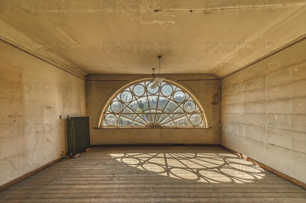 An empty room with a large, barred window that casts a shadow play on the floor, Schachtrupp Villa, Lost Place, Osterode am Harz, Lower Saxony, Germany, Europe