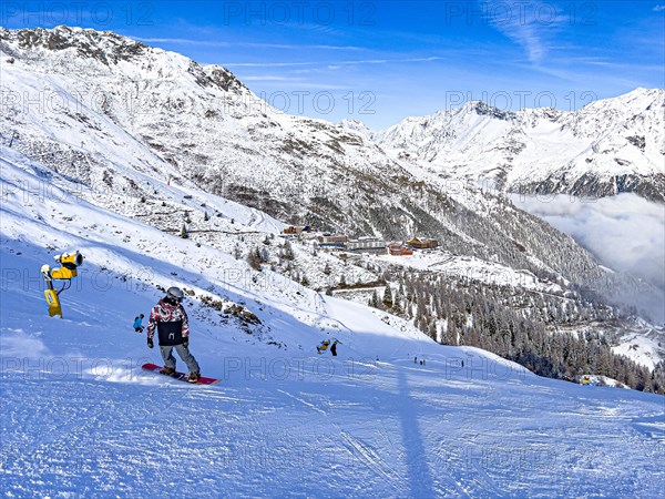 Snowboarders on the ski slope in front of the Hochsoelden hotel settlement in the Soelden ski resort, Tyrol
