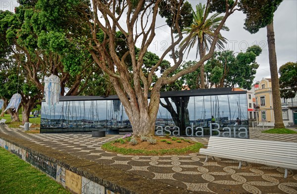 Modern glass building opposite historic houses in a green park, Horta, Faial Island, Azores, Portugal, Europe