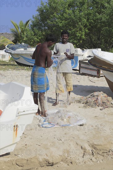 Men with fishing nets on tropical beach at Pasikudah Bay, Eastern Province, Sri Lanka, Asia