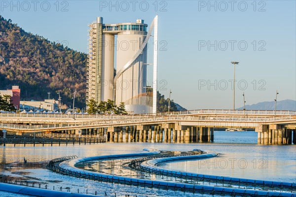 Yeoso, South Korea: December 25, 2017: Sky Tower (written in Korean letters) located in Yeosu, South Korea with ocean and foot bridge in forground