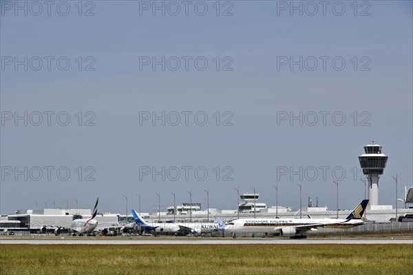 Heavy traffic with Singapore Airlines Airbus A350-900, Emirates Airways Airbus A380-800 and Kuwait Airlines at Terminal 1 with control tower, Munich Airport, Upper Bavaria, Bavaria, Germany, Europe