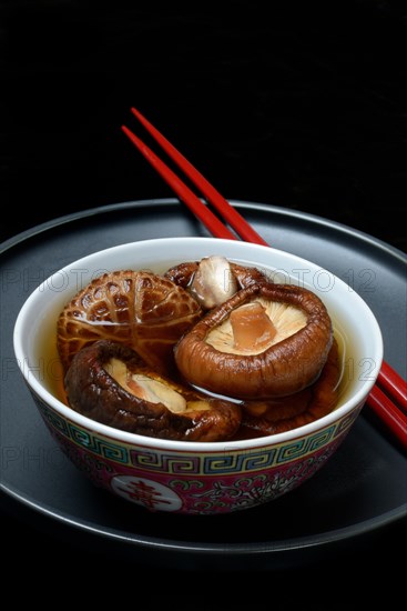 Dried shiitake mushrooms in a bowl, soaked in water