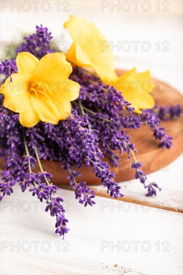 Beautiful day lily and lavender flowers on white wooden background, side view, close up, selective focus