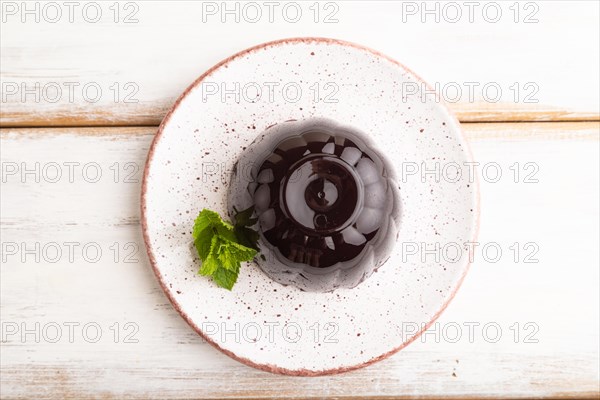 Black currant and grapes jelly on white wooden background. top view, flat lay, close up