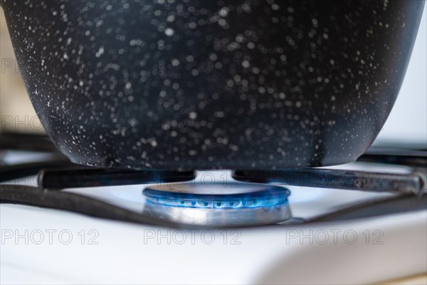 Closeup view of a pan on a gas hob, cooking on a gas stove