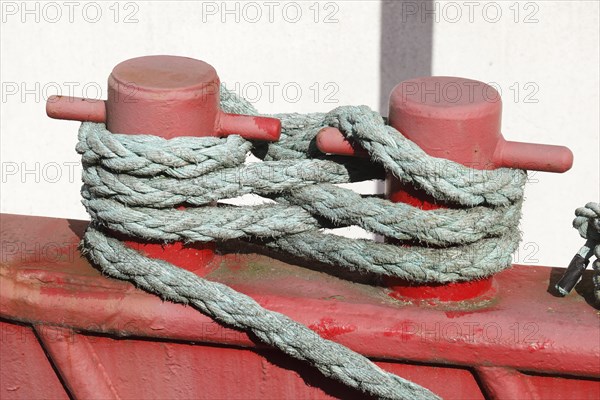 Red ship's bollard wrapped with ship's rope, mooring line, Germany, Europe