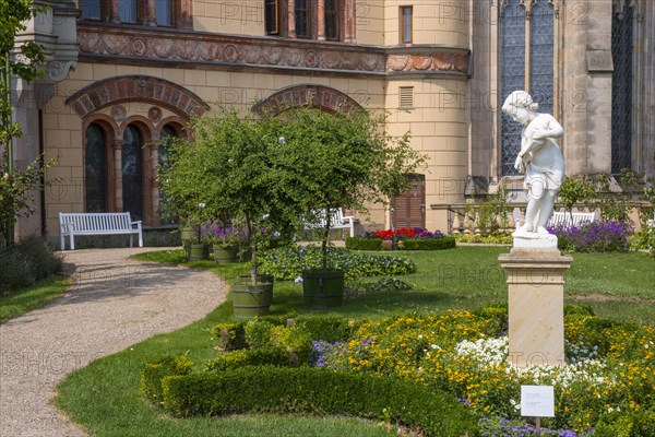 Castle garden with white marble sculpture The Allegory of Water or Boy with Shell Horn by Christian F. Genschow, statue, figure, in the background Schwerin Castle, east facade and parts of the castle church, Schwerin, Mecklenburg-Vorpommern, Germany, Europe