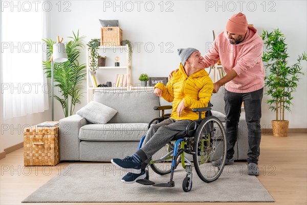 Happy disabled man with a and friend holding the wheelchair at home