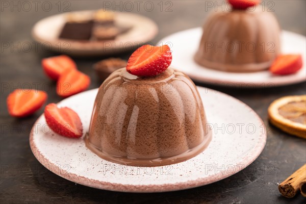 Chocolate jelly with strawberry on black concrete background. side view, close up, selective focus