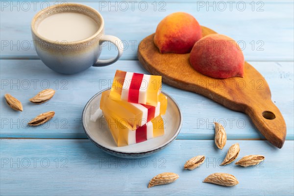 Almond milk and peach jelly on blue wooden background. side view, close up